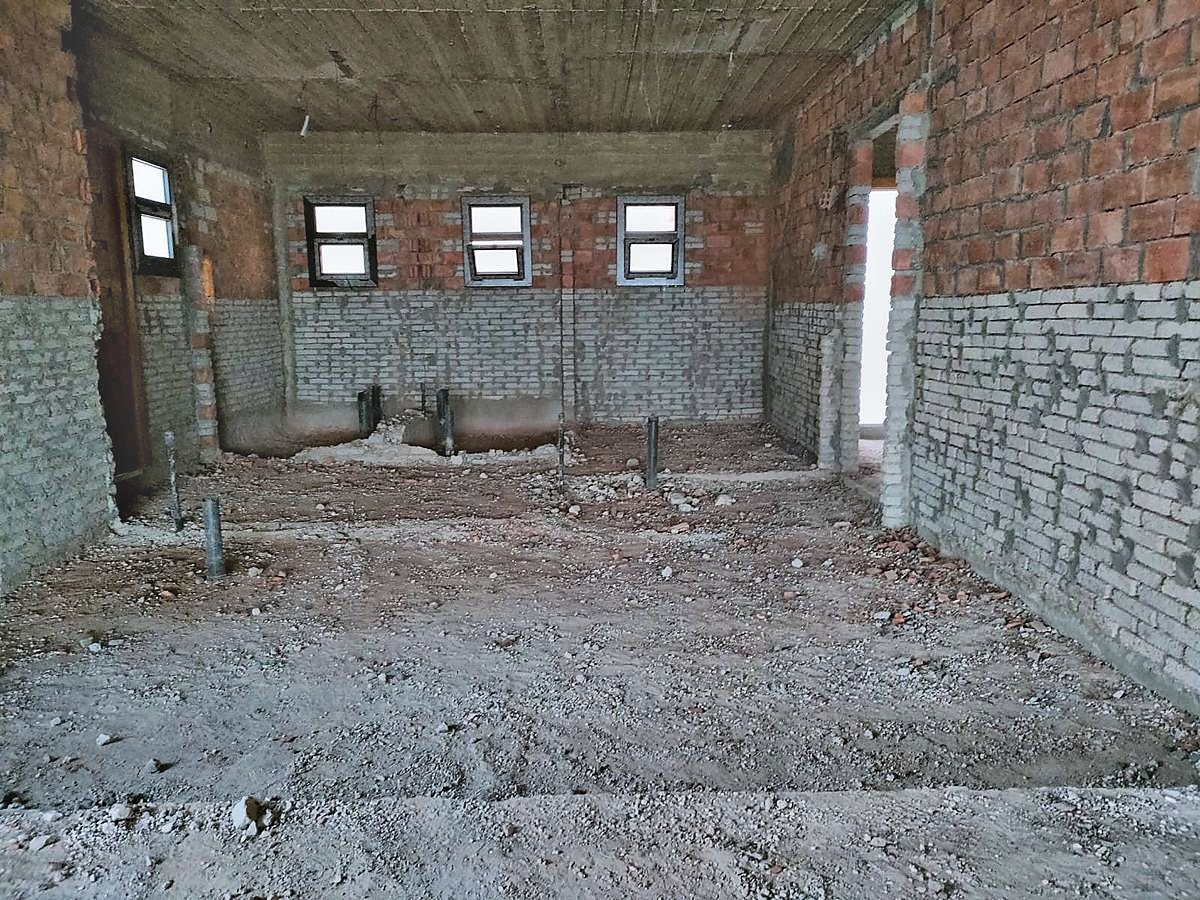 The same room cleared, pipe stubs standing proud of the floor