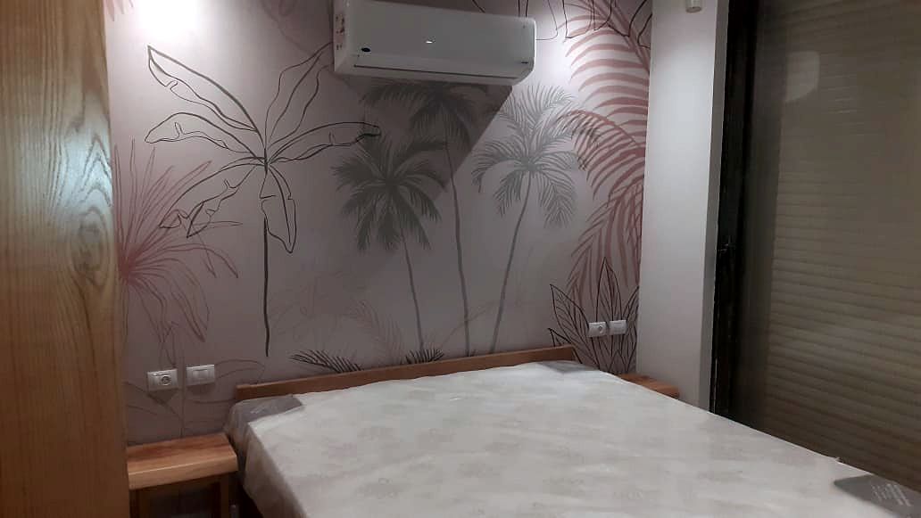A hand-painted palm mural finished over skimmed plaster