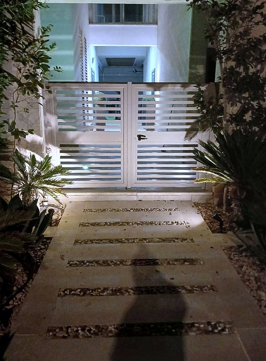 Slatted metal gates being installed at night