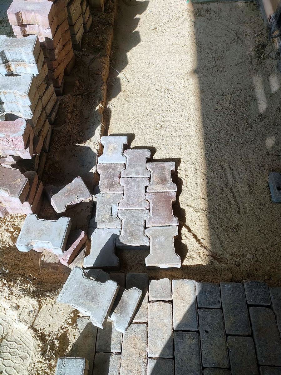 Concrete interlock pavers going down on a screeded sand bed