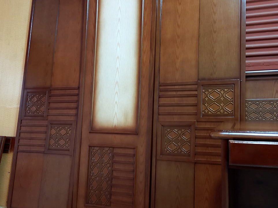 Stained wardrobe door panels with carved lattice and louvre details