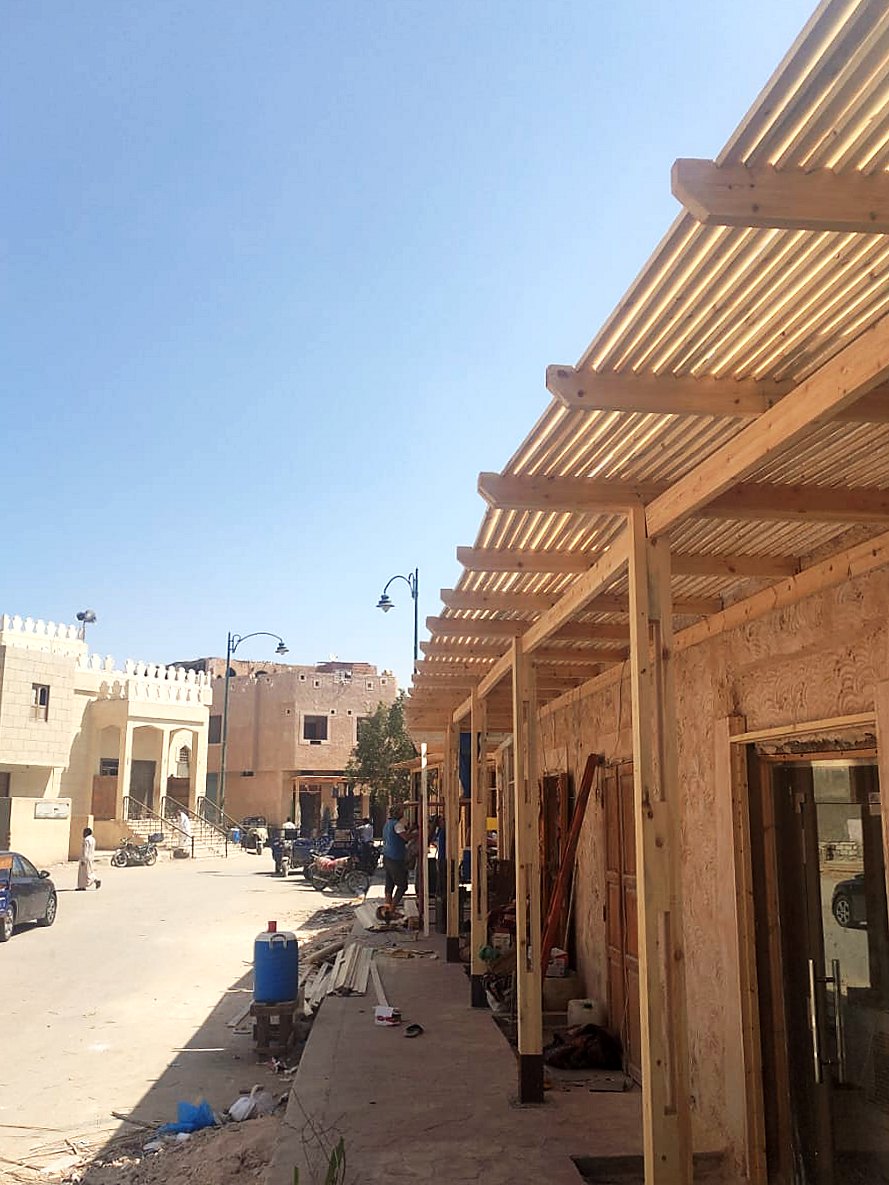 Continuous timber pergola along the rendered shopfronts