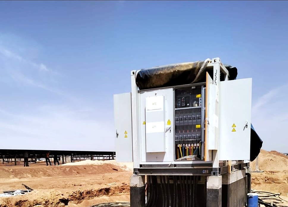 String inverter and combiner station on a cast plinth — desert solar plant