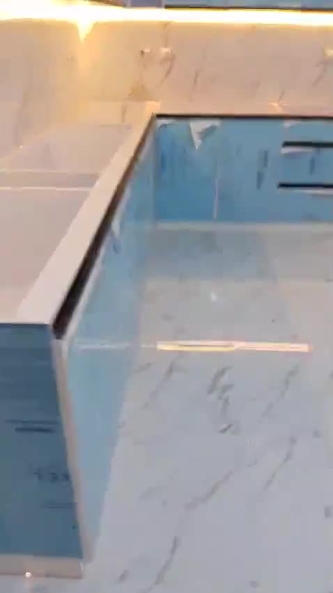 L-shaped kitchen with under-cabinet LEDs, doors still in protective film